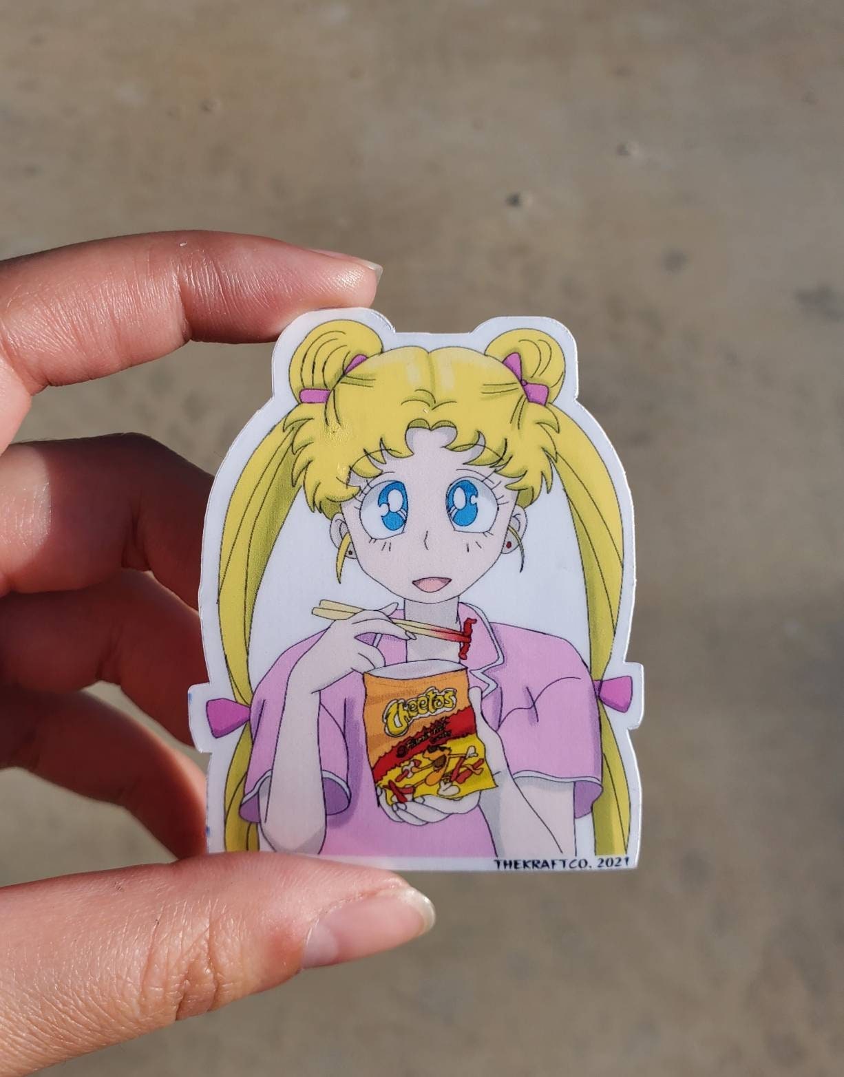 Sailor moon eating hot Cheetos with chopsticks laminated sticker.